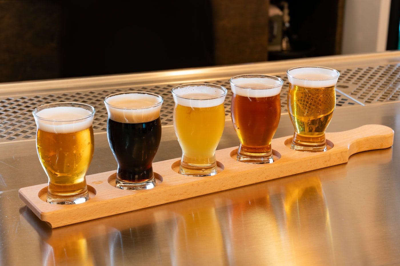A flight of craft beers on a wooden paddle