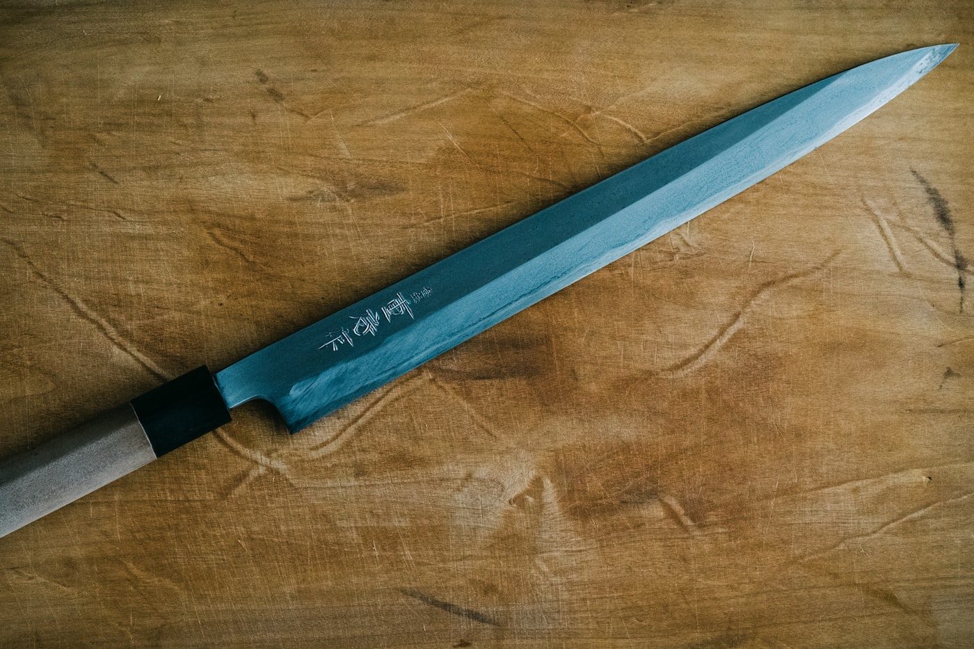 A Japanese chef’s knife on a wooden board