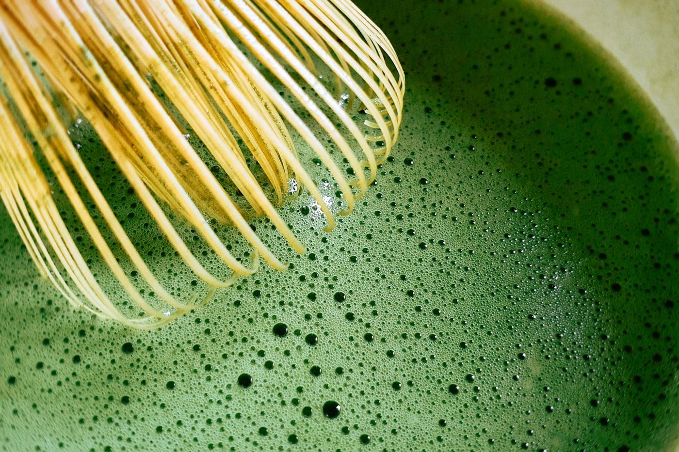 Matcha green tea being whisked in a bowl